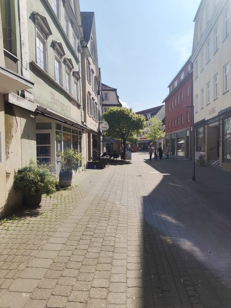 Blick auf eine ruhige Stadtstraße mit Bäumen und historischen Gebäuden.